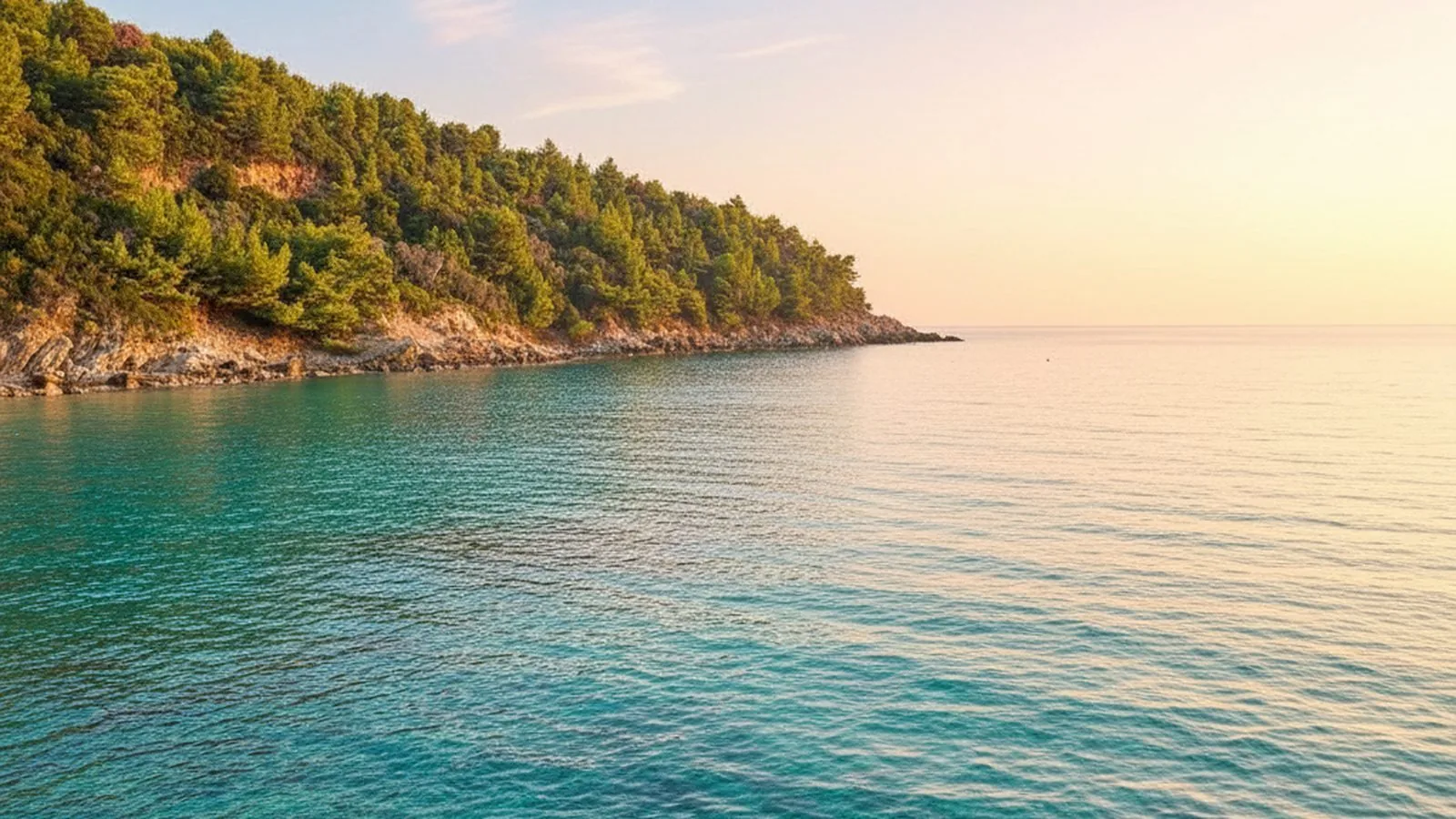 La costa della Messenia al tramonto, con il promontorio scuro sul mare calmo