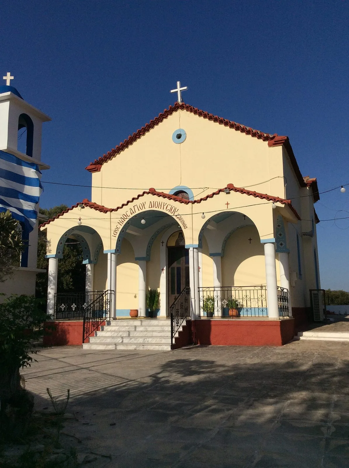 La chiesa del paese di Petrochori, in Messenia, con la bandiera greca accanto all'ingresso